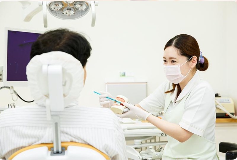 歯科医師がインプラントについて患者さんに説明している場面